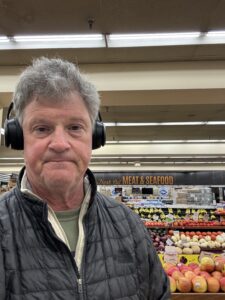 Greg Schwem weaering large headphones in a grocery store